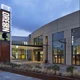 The exterior of OCC's main entrance featuring a large metal sign lit with "Oregon" and a digital sign at twilight. 
