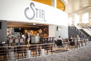 Modern bistro lounge with patrons seated at tables.
