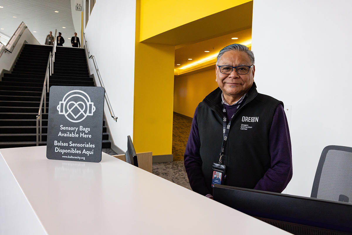 Photo of OCC Welcome Agent with KultureCity Sensory Bags sign.