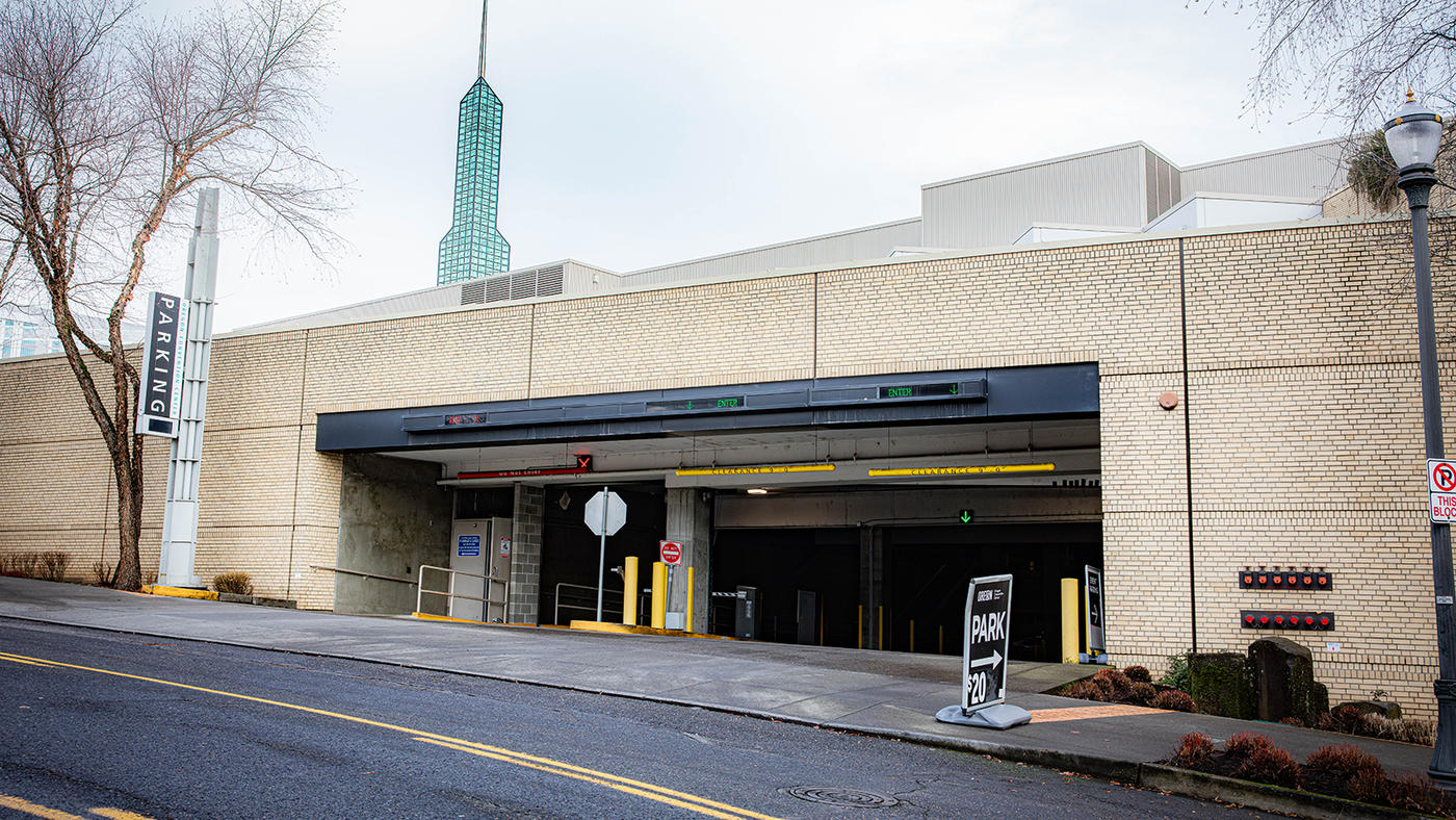 A parking garage entrance with two entrances and one exit