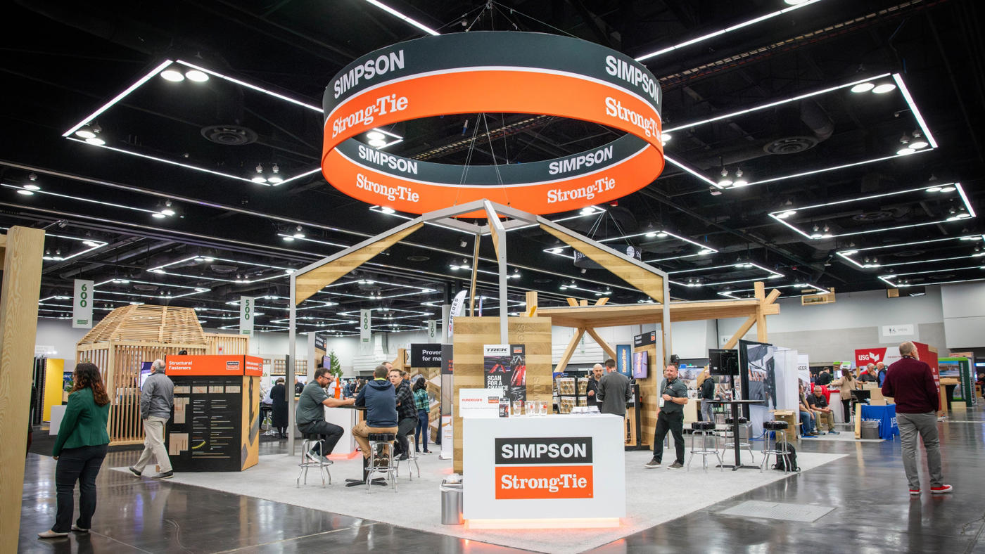 a large circular sign hangs high overhead inside an exhibit hall