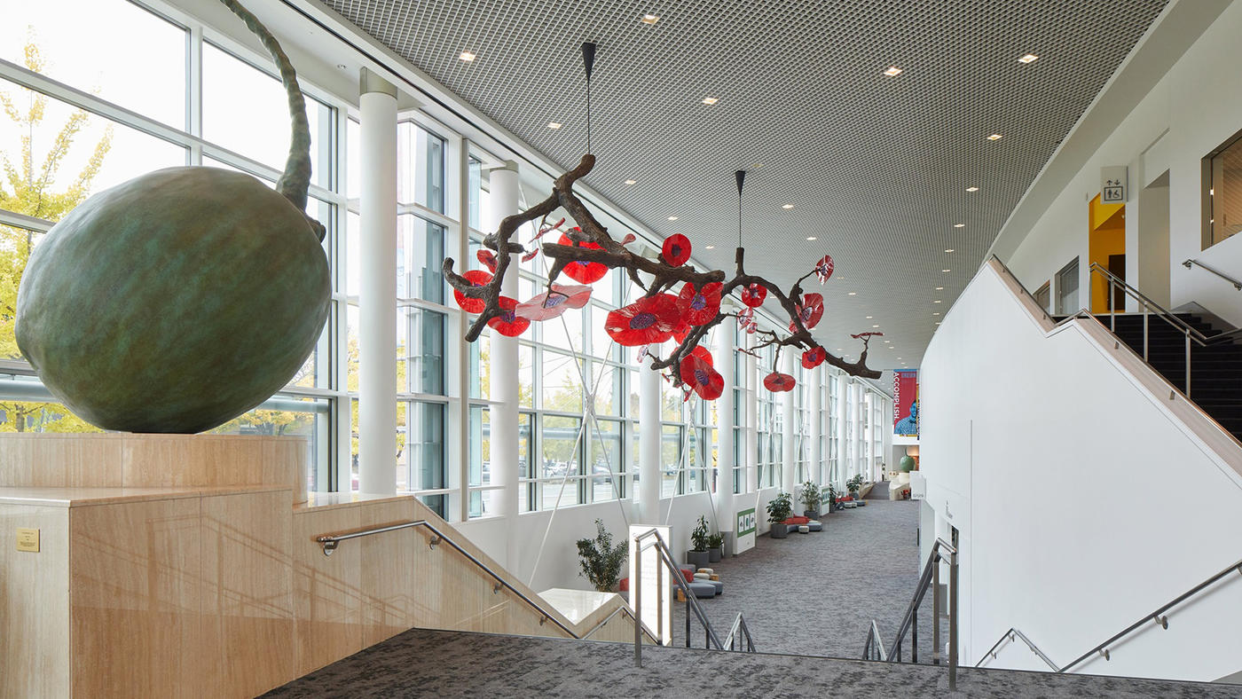 A tangle of 12-foot branches with bright red and purple glass flowers is suspended from the OCC ceiling.