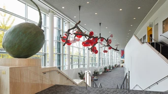 Glass floral sculptures line a bright building concourse.