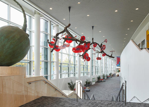 A tangle of 12-foot branches with bright red and purple glass flowers is suspended from the OCC ceiling.