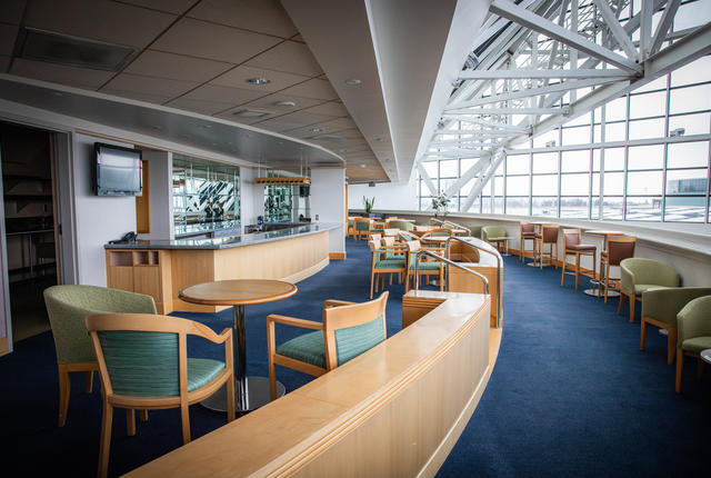 a relaxed bar area with seating and a view of Portland's city skyline seen through the base of OCC's spires